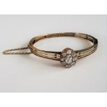 A diamond set hinged bangle, circa late 19th Century, set with a diamond cluster,