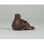 A Japanese wood netsuke of a recumbent goat, Edo period, 19th century, signed, (a,f), 4.25cm.