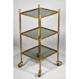 A mid-20th century lacquered brass and smoked glass three tier etagere, on reeded supports,