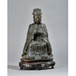 A Chinese bronze figure of a dignitary, Ming dynasty, seated in meditation with hands clasped,