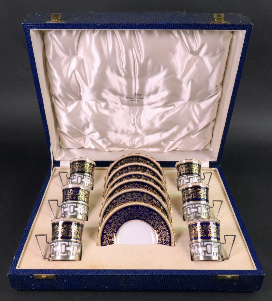 A cased set of six Aynsley coffee cans and saucers, the cans in pierced silver holders,