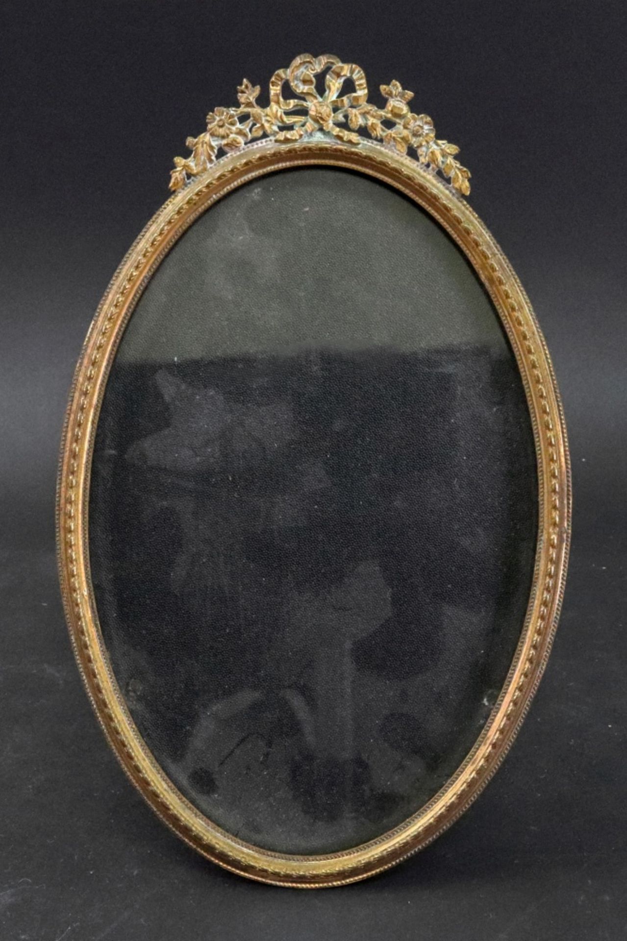 An oval French gilt metal easel photograph frame, late 19th century,