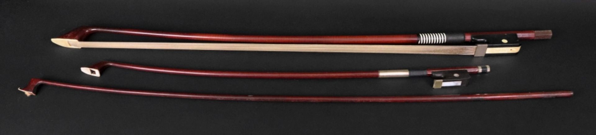 Three Violin bows, one mahogany and ebony, stamped Prima 200, with bone,