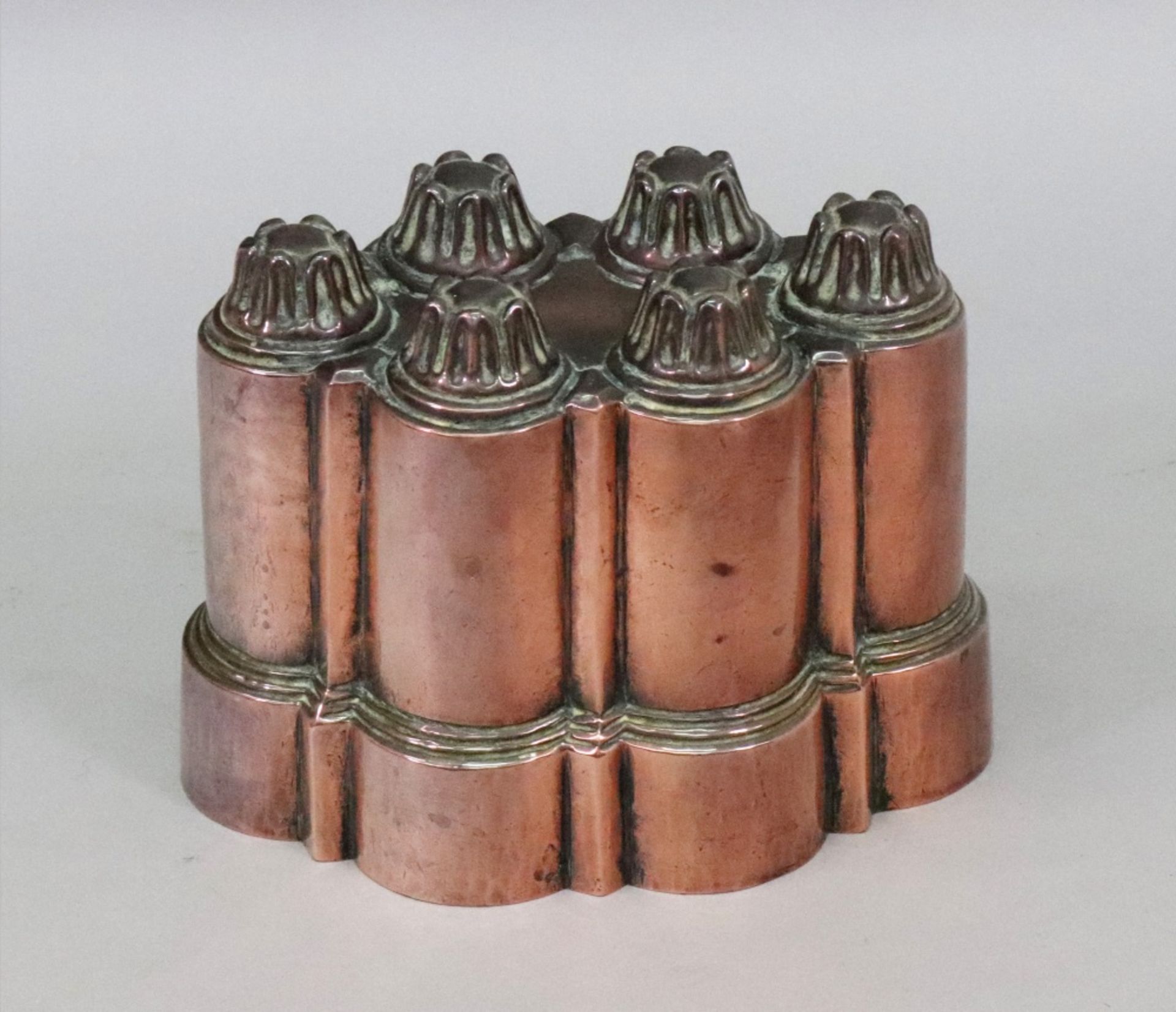A Victorian copper Belgrave jelly mould, with six crown topped towers on a stepped shaped base,