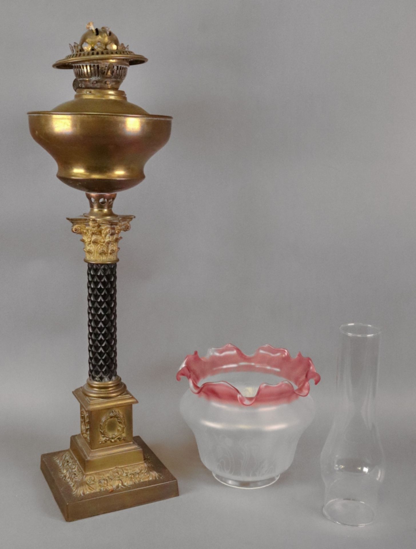 A late Victorian gilt metal oil lamp, with carved ebonised column,