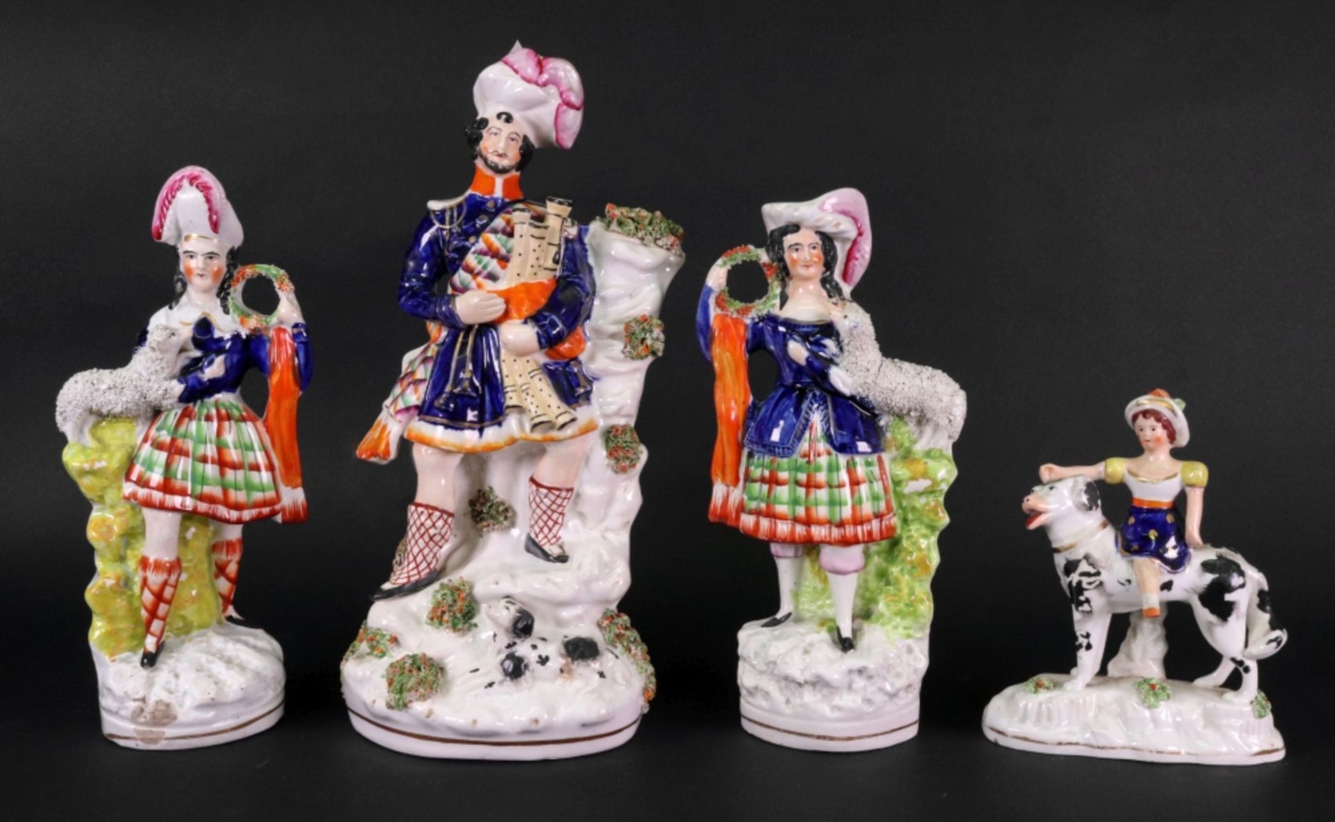 A pair of Victorian Staffordshire pottery highland figures, each with a pet lamb, 23.