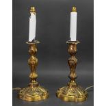 A pair of Louis XV style gilt metal candlesticks, 19th century, of silver shape,