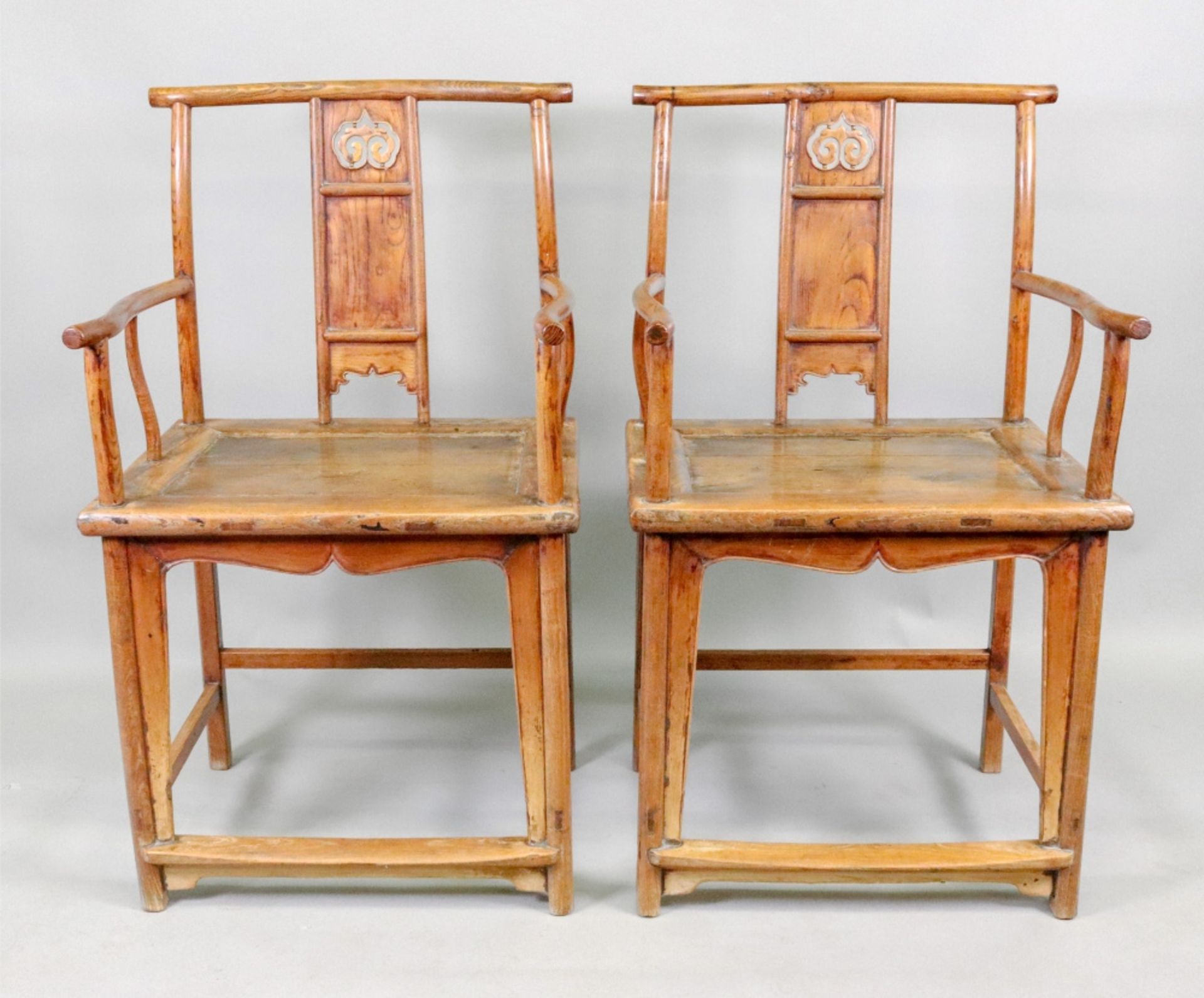 A pair of Chinese open arm elbow chairs, with carved and pierced and panelled splats,