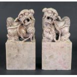 A pair of Chinese soapstone groups of Buddhist lions, the male with a brocade ball,