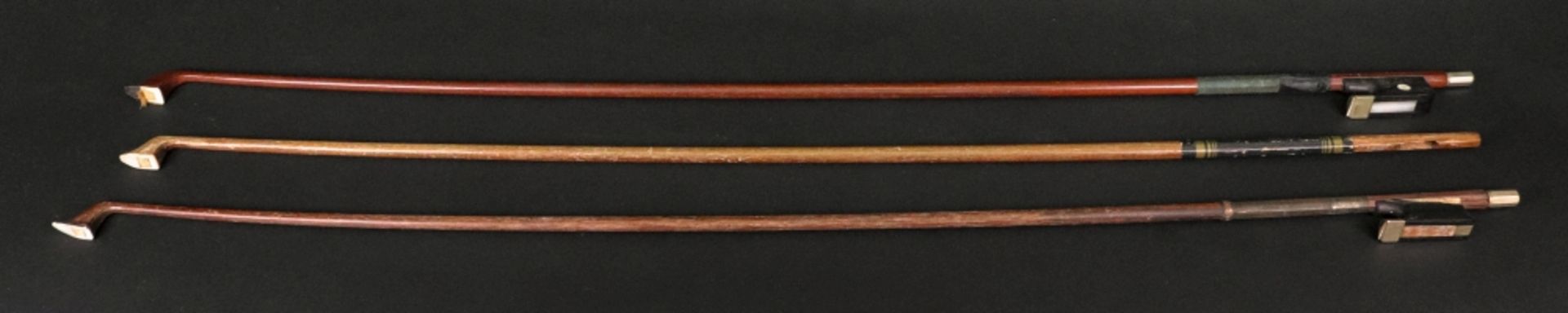 Three violin bows, one mahogany and ebony, stamped Czechoslovakia, with mother of pearl,
