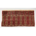 A Yomut Juval rug, with six rows of guls, on a crimson ground, 133 x 67cm.