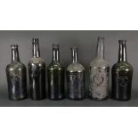 A collection of six old green glass wine and spirits bottles,