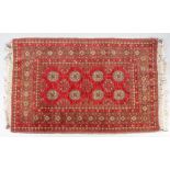 An Afghan rug, with two rows of four gulls on a red ground, within a border with a repeated design,