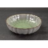 A Chinese Guan-style bowl, covered in a crackled celadon glaze, notched rim, 15.5cm diameter.