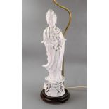 A Chinese blanc de chine figure of guanyin, 20th century, holding a lotus flower,