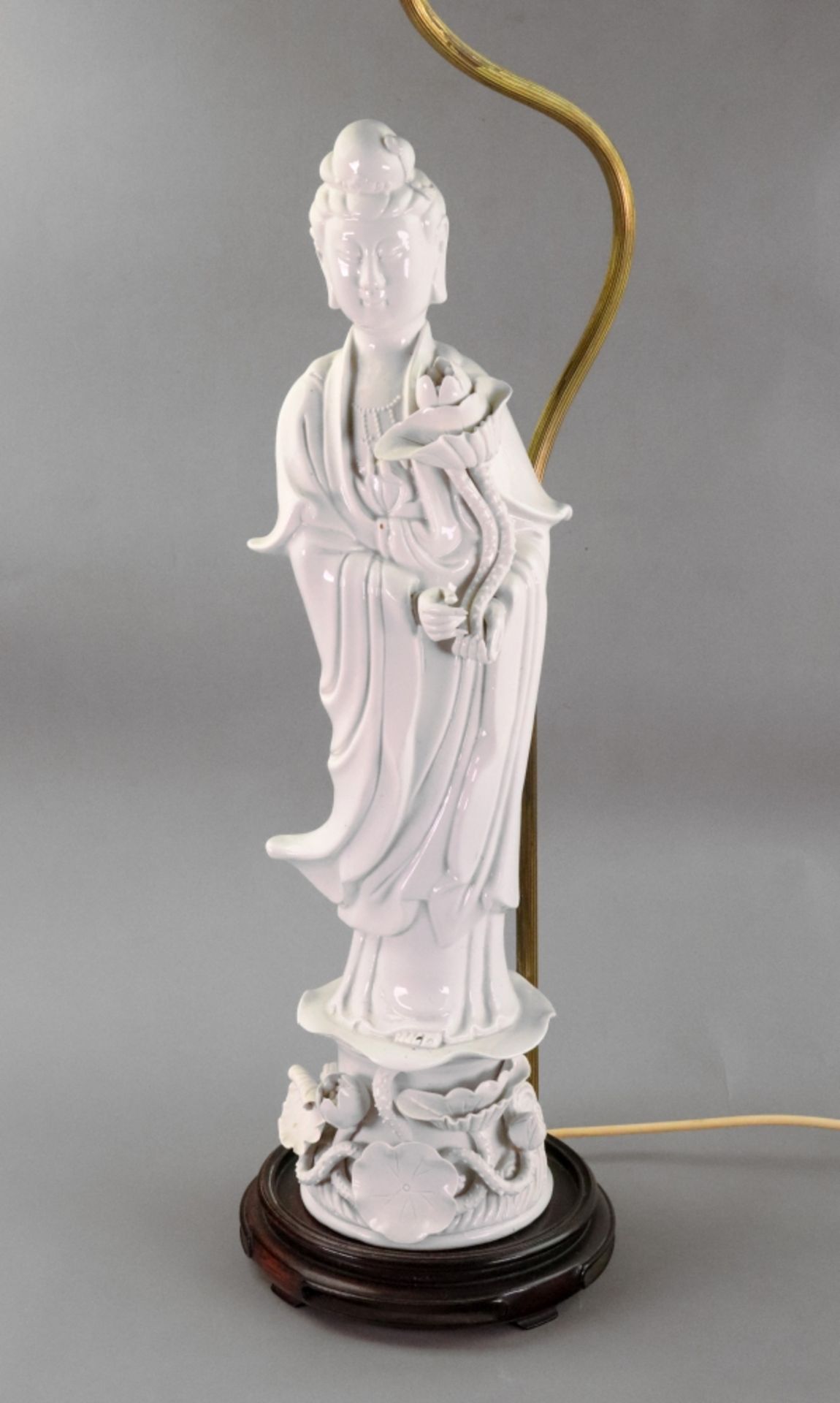 A Chinese blanc de chine figure of guanyin, 20th century, holding a lotus flower,