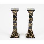 A pair of Baccarat black glass candlesticks, square section with gilt engraved foliate decoration,