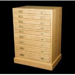 A modern oak collectors chest of nine long graduated drawers on plinth base, 70cm wide x 100cm high.