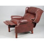 A modern hardwood framed and brown leatherette upholstered reclining wingback armchair,