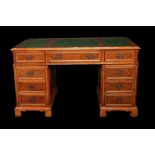 A modern walnut and stained beech pedestal desk with nine drawers and green leather inset top,