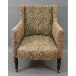 An early Victorian upholstered armchair, on grained faux rosewood legs and castors.