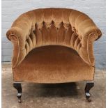 An Edwardian button down upholstered tub back armchair on cabriole legs.