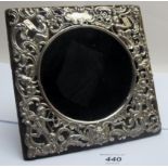 A silver photo frame decorated with scrolls and cherubs, London 1901, William Comyns,