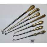A collection of eight silver handled button hooks,
