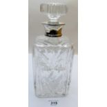 A heavy cut glass decanter with silver collar,