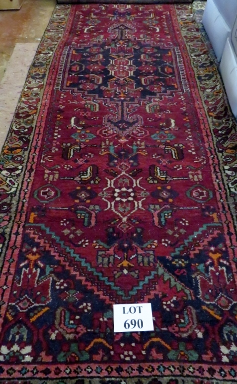 A mid 20th century Persian runner with central medallions and flowered border (284 cm x 97 cm