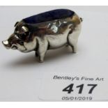 A silver pig pin cushion,