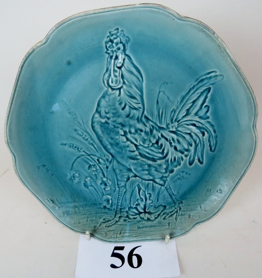 A late 19th century Art Pottery charger, modelled in relief with a cockerel under pale blue glaze,