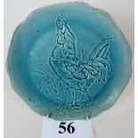 A late 19th century Art Pottery charger, modelled in relief with a cockerel under pale blue glaze,