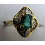 An 18ct gold ring with centre emerald, approx 9 x 5 mm, and 20 baguette cut diamonds, size I,