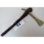 An old tribal brass axe with cut decoration and wooden handle with incised linear designs,