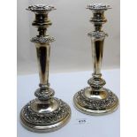 A pair of Georgian silver candlesticks with embossed decoration, approx 11" high,