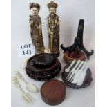 A collection of Asian decorative objects, including bone and mother of pearl cutlery, resin figures,