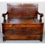 A small 18th century oak settle, with carved back panels, over a lift up seat,