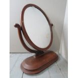 A Victorian carved mahogany oval table top mirror terminating on a plinth base,