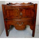 A Georgian mahogany commode with double panelled doors, over a pull out base,