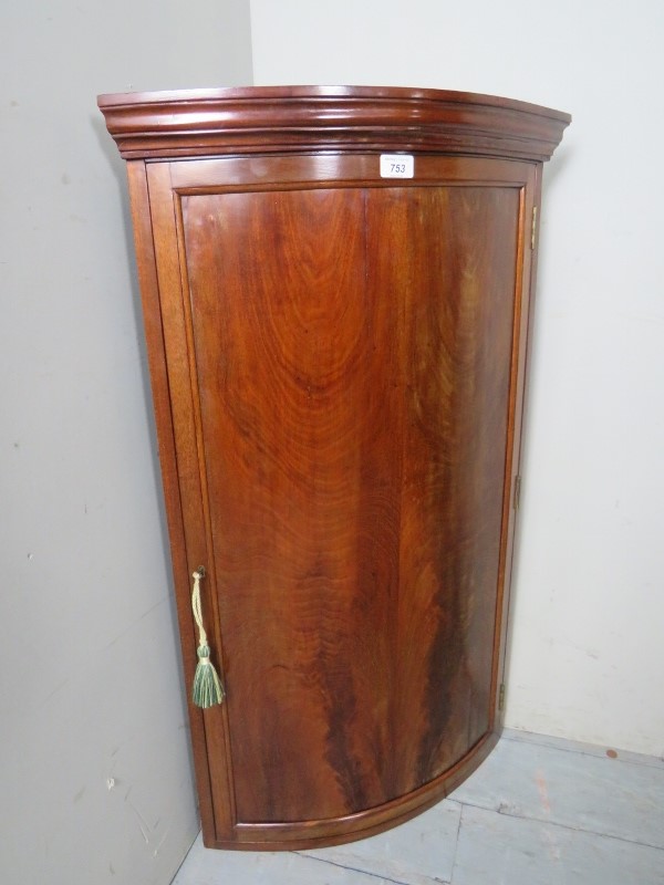 A 19th century bow front corner cupboard with a single door,