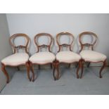 A set of four Victorian walnut spoon back dining chairs,