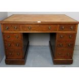 A small Victorian oak pedestal desk with a tooled tan leather,