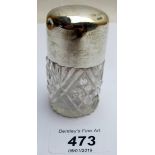 A cut glass scent bottle with silver top