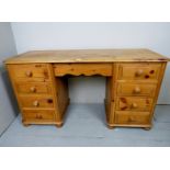 A late 20th Century pine desk with a cen