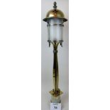 An Arts & Crafts brass newel post light, with typical stylised decoration and frosted glass shade,