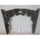 Two Chinese wall brackets, one an early heavy cast bronze of a dragon's head,