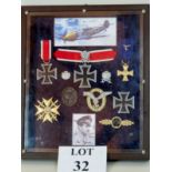 A wall mounted display case of WWII German Air Force style memorabilia to include a Knight's Cross,