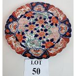 A 19th century Imari plate decorated with garden scenes in red, blue and greens,