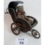 An antique-style toy pram, complete with appropriately sized Teddy bear,